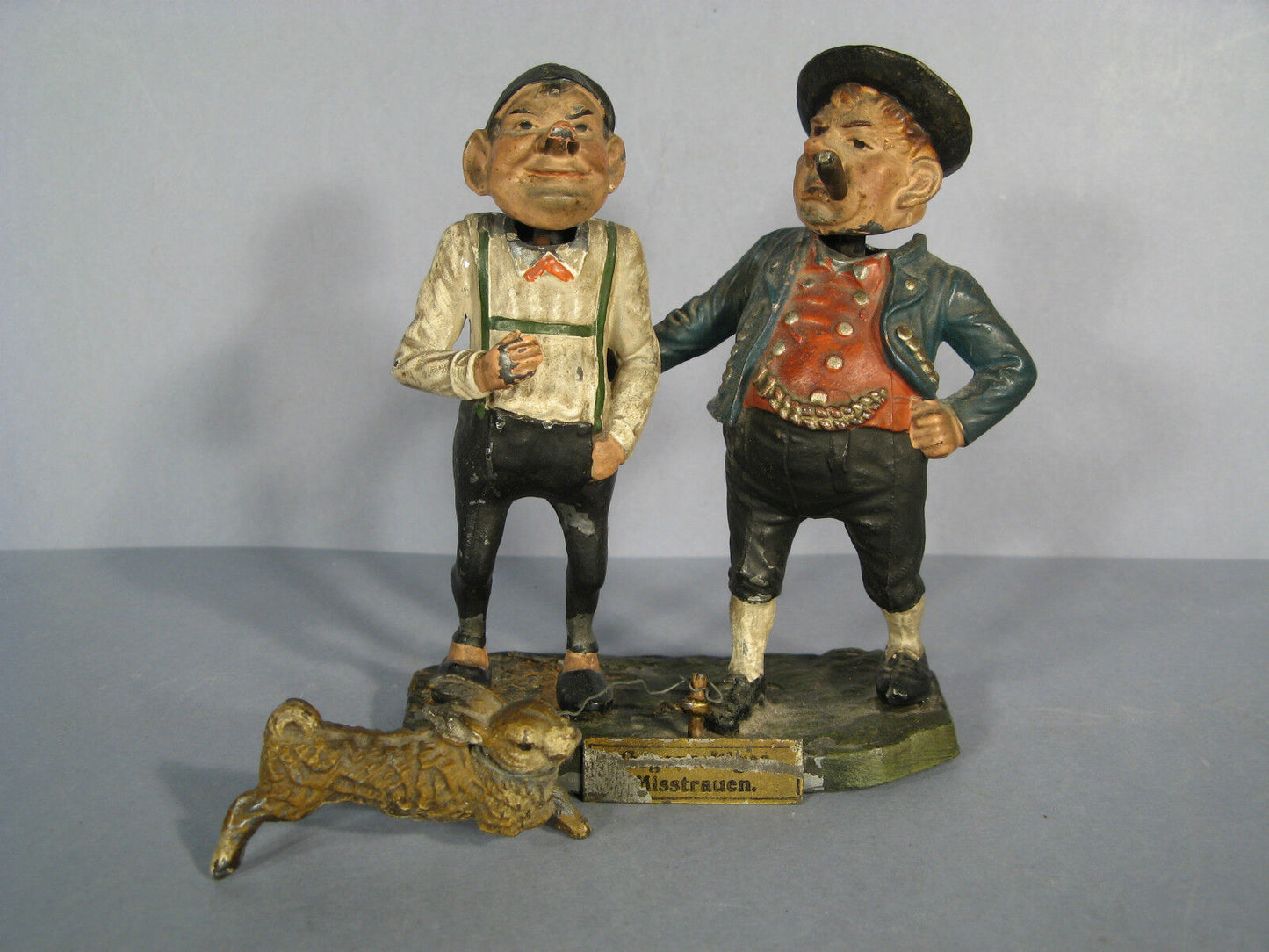 "Misstrauen" caricature sculpture featuring two figures and a hare.
