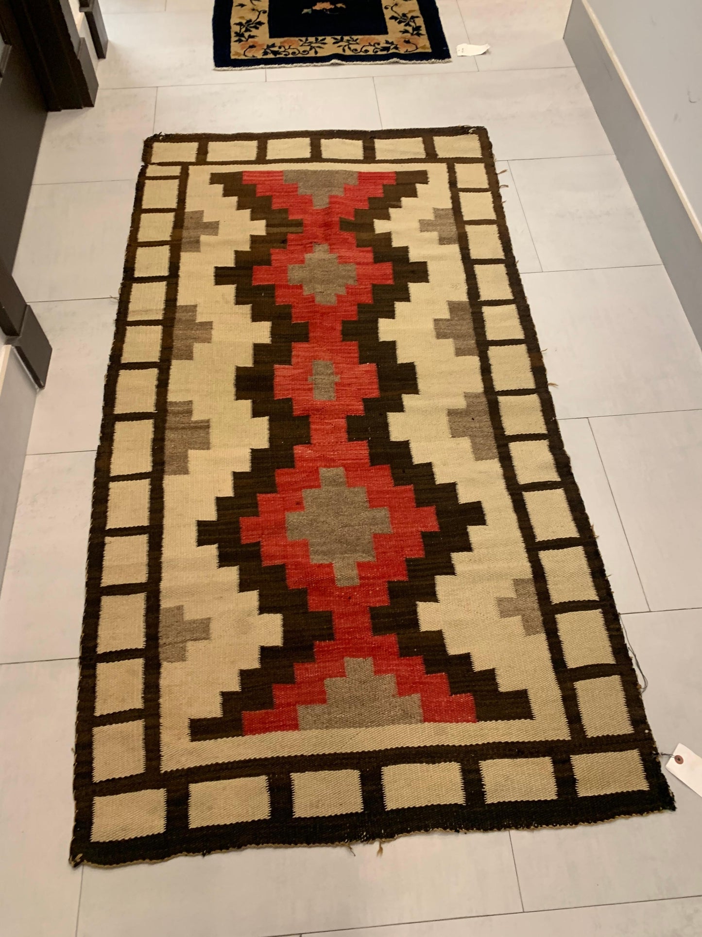 Traditional Native American Navajo weaving with red, beige, brown, and black colors
