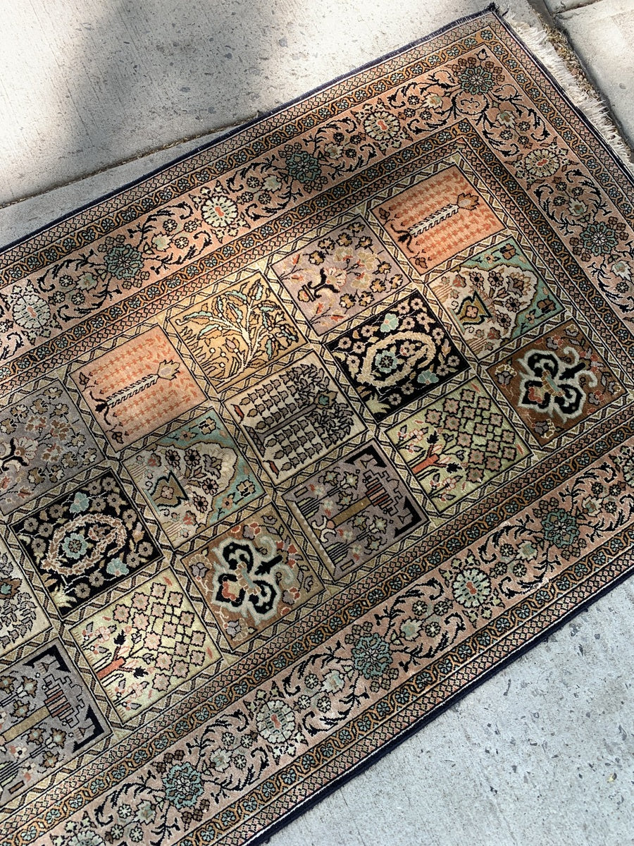 Hand-knotted Qum rug featuring a panel design with botanical motifs.
