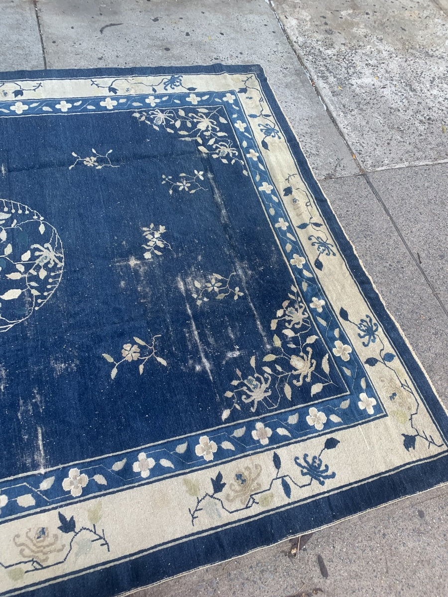 Close-up of the floral details on an antique Chinese wool rug.
