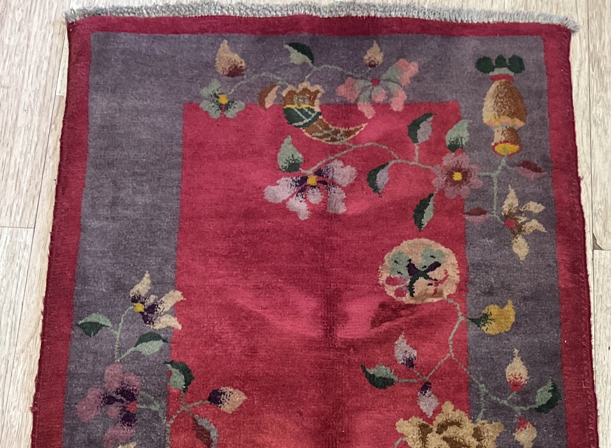 Close-up of the intricate blossoms and foliage on the vintage wool rug
