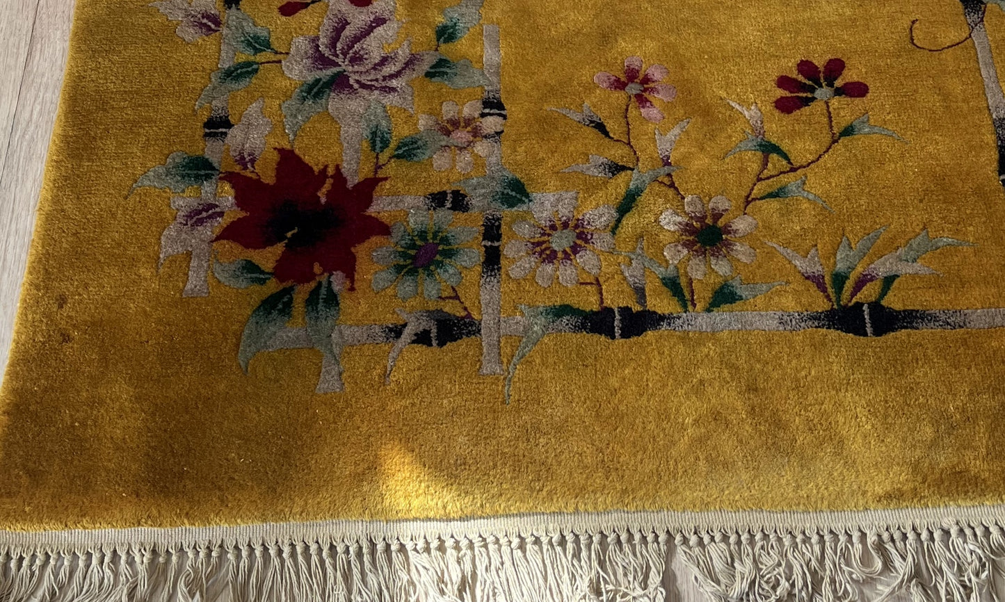 Golden-yellow background with intricate floral motif on Art Deco rug
