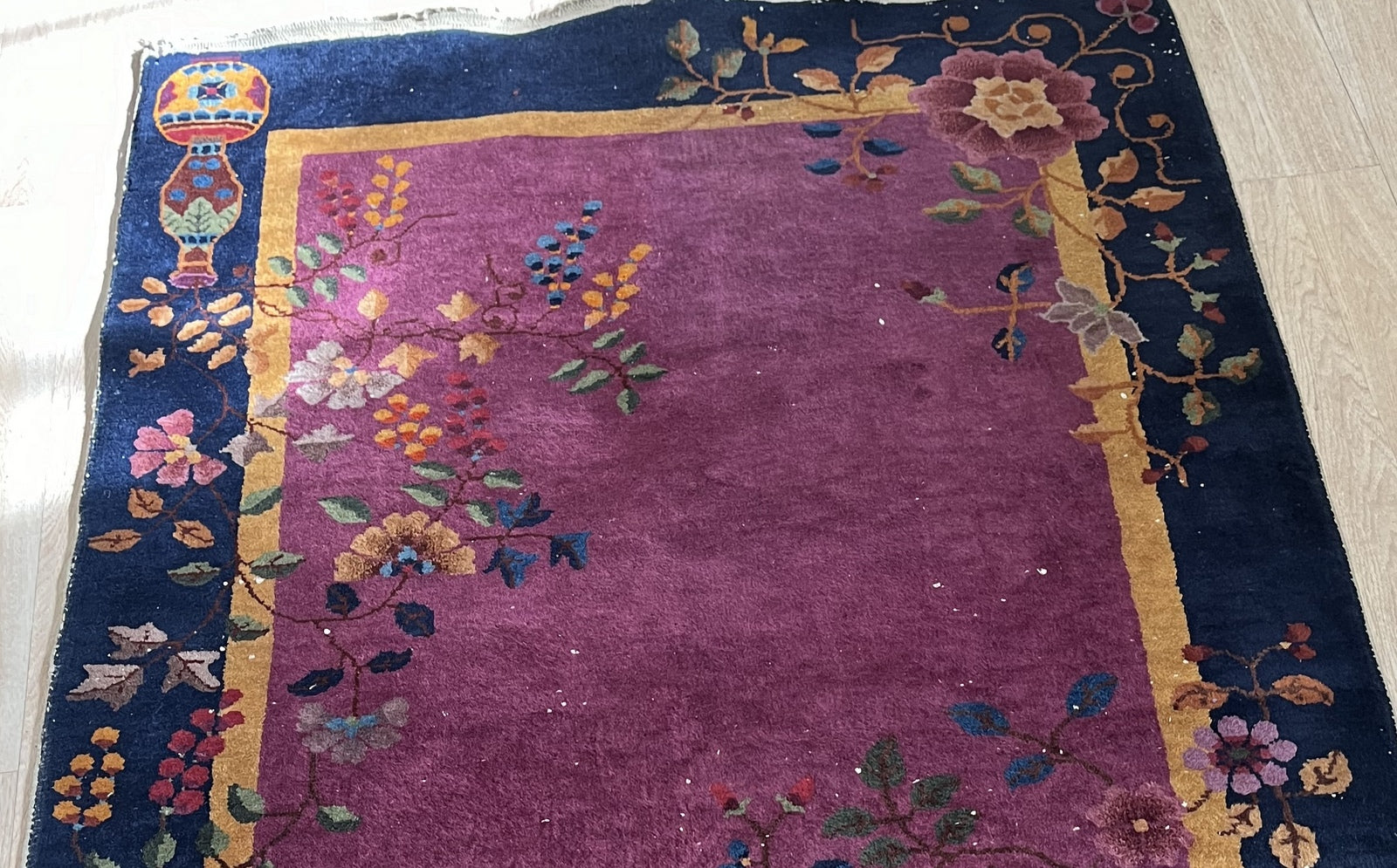 Close-up of floral and botanical design on antique Chinese wool rug
