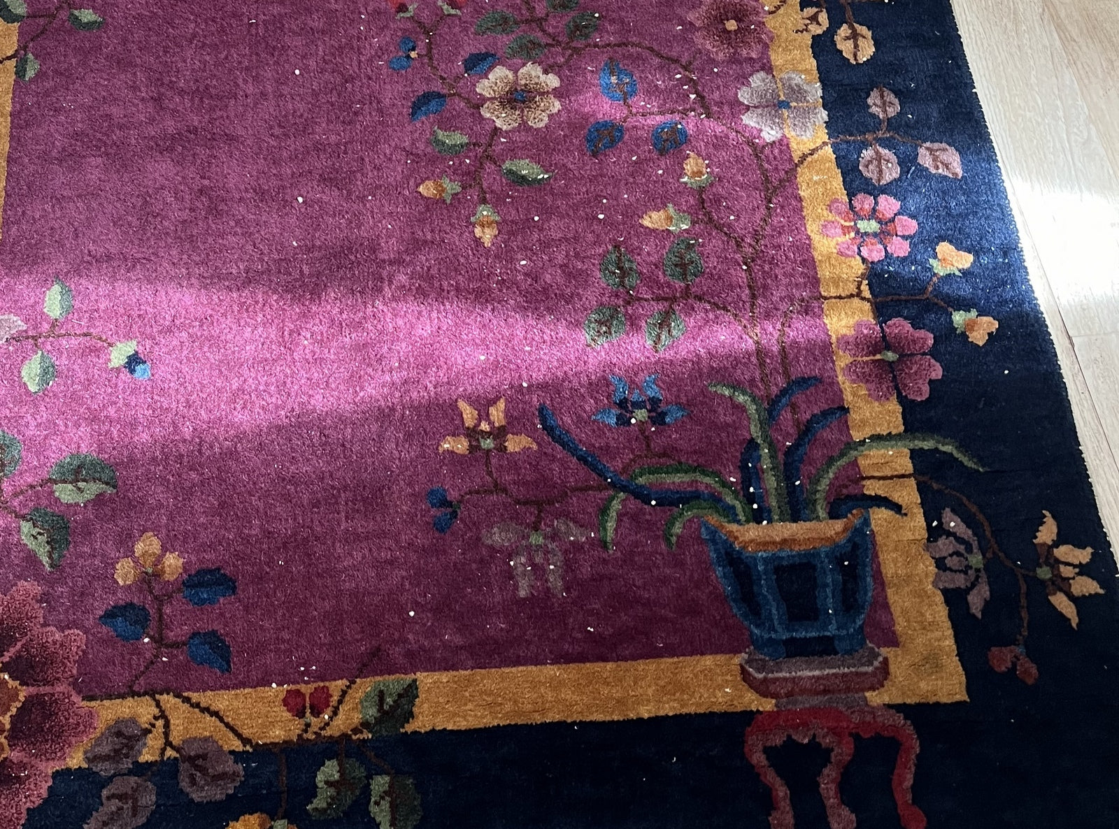 Detailed view of pink, yellow, and blue flowers on the vintage rug
