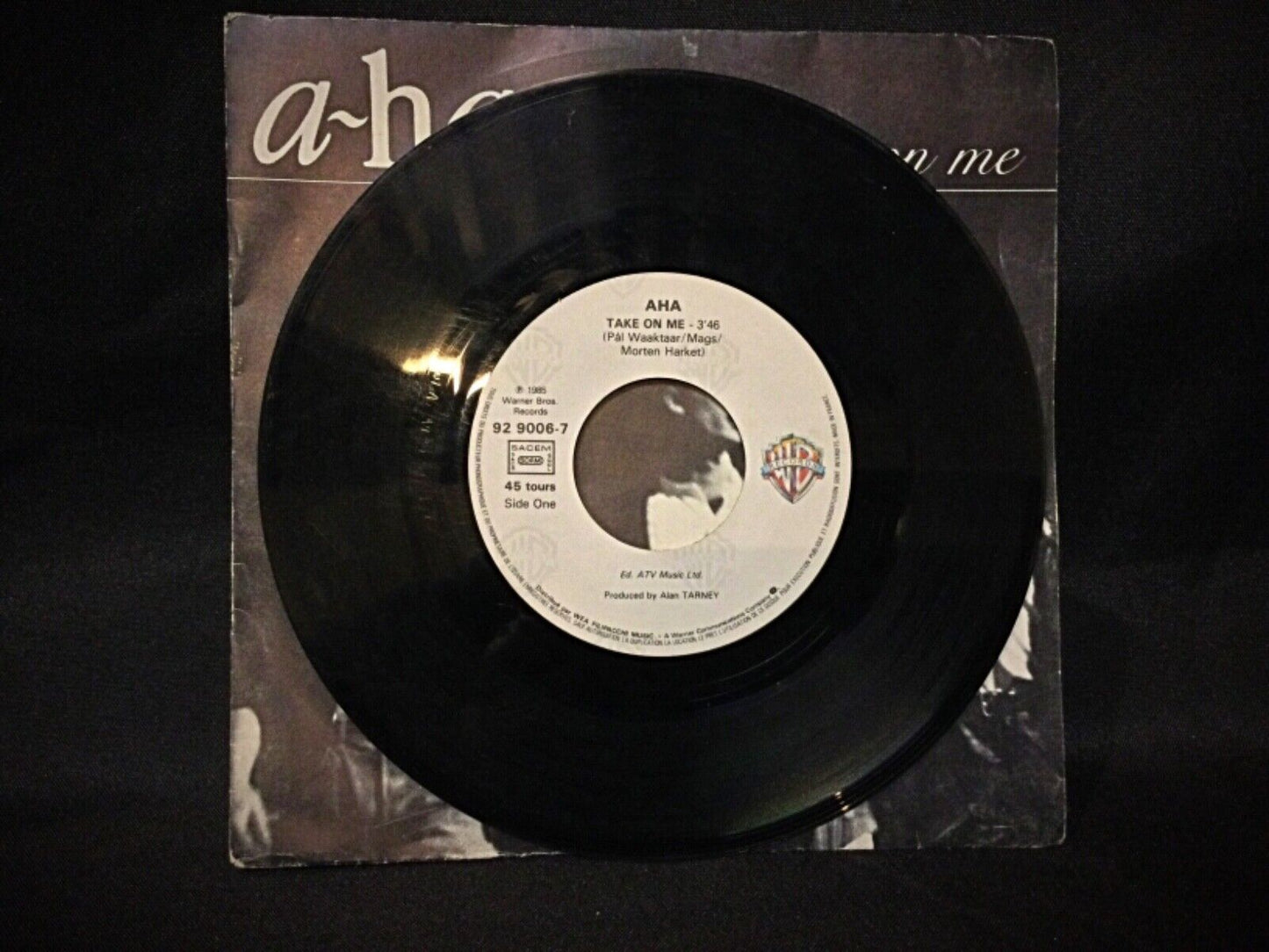 Vintage A-Ha "Take on Me" 45 RPM vinyl displayed with its original cover, highlighting its nostalgic 80s rock appeal.