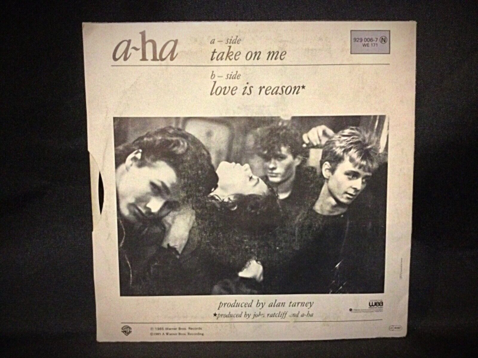 A-Ha "Take on Me" 45 RPM vinyl record alongside its cover, illustrating the classic 1980s music memorabilia.