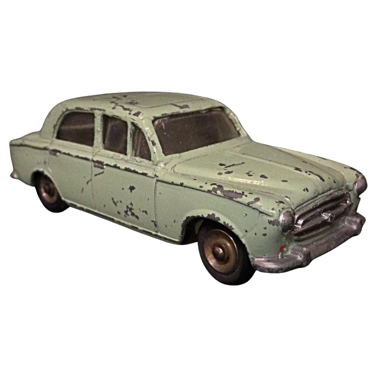 Vintage Dinky Toys Peugeot 403 toy car, showing its classic die-cast metal body.
