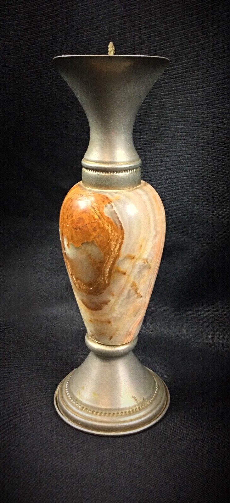 Close-up of a vintage onyx vase with pewter frame detailing
