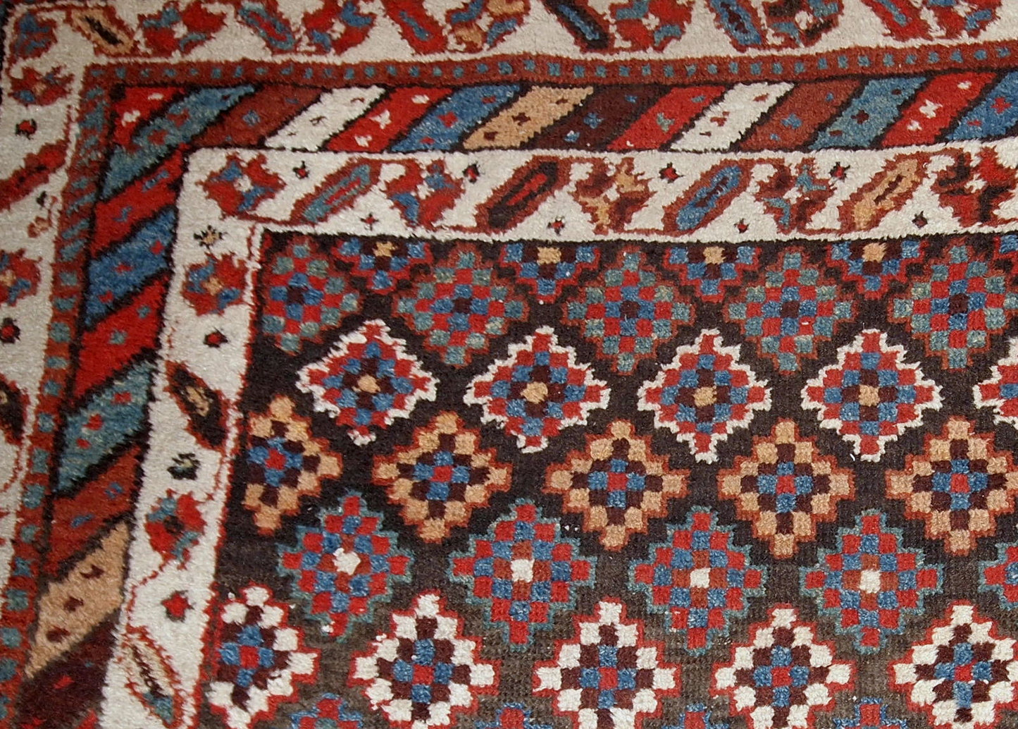 Antique handmade Northwest Persian rug in original good condition from 1880s. The rug made in repeating geometric pattern in colorful shades.