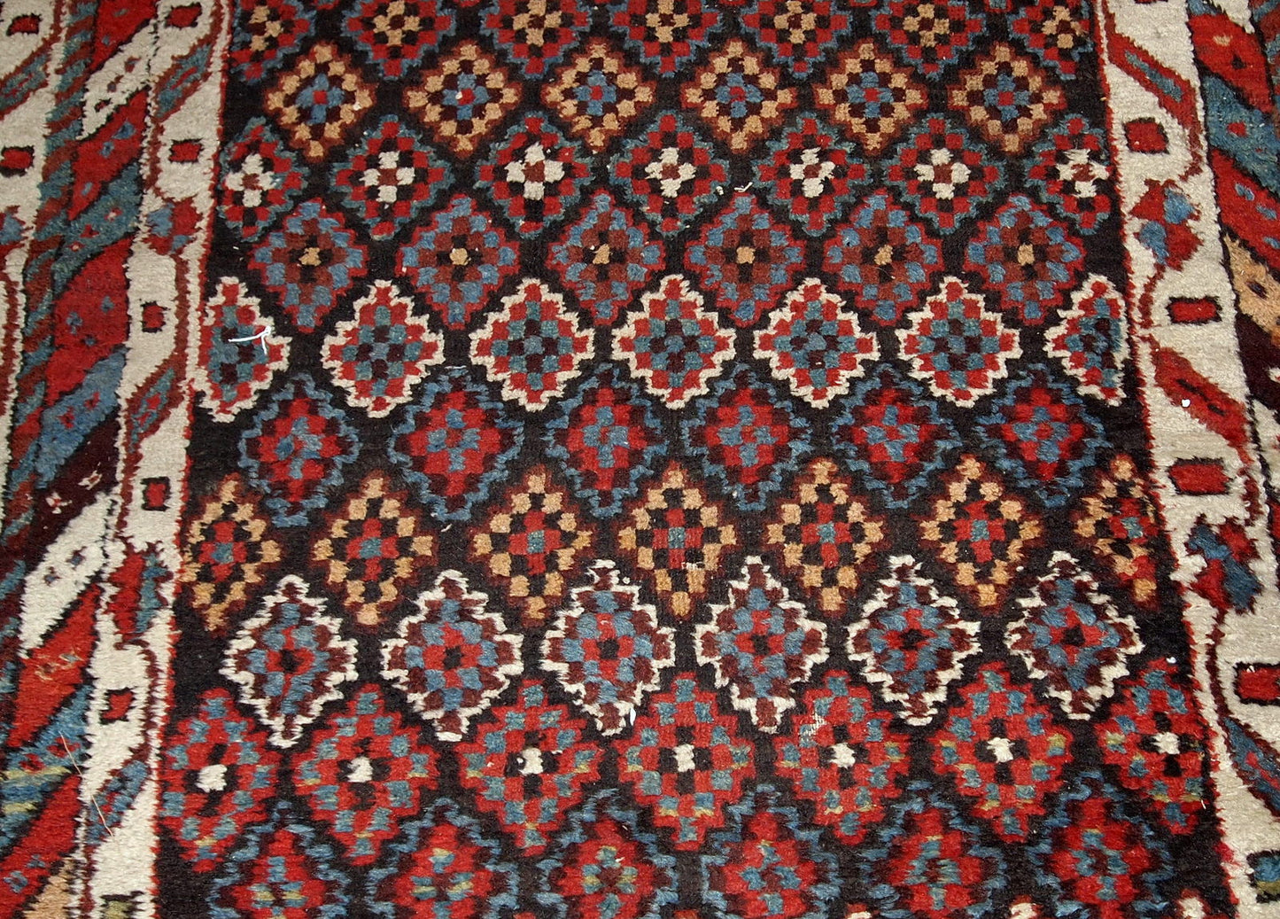 Antique handmade Northwest Persian rug in original good condition from 1880s. The rug made in repeating geometric pattern in colorful shades.