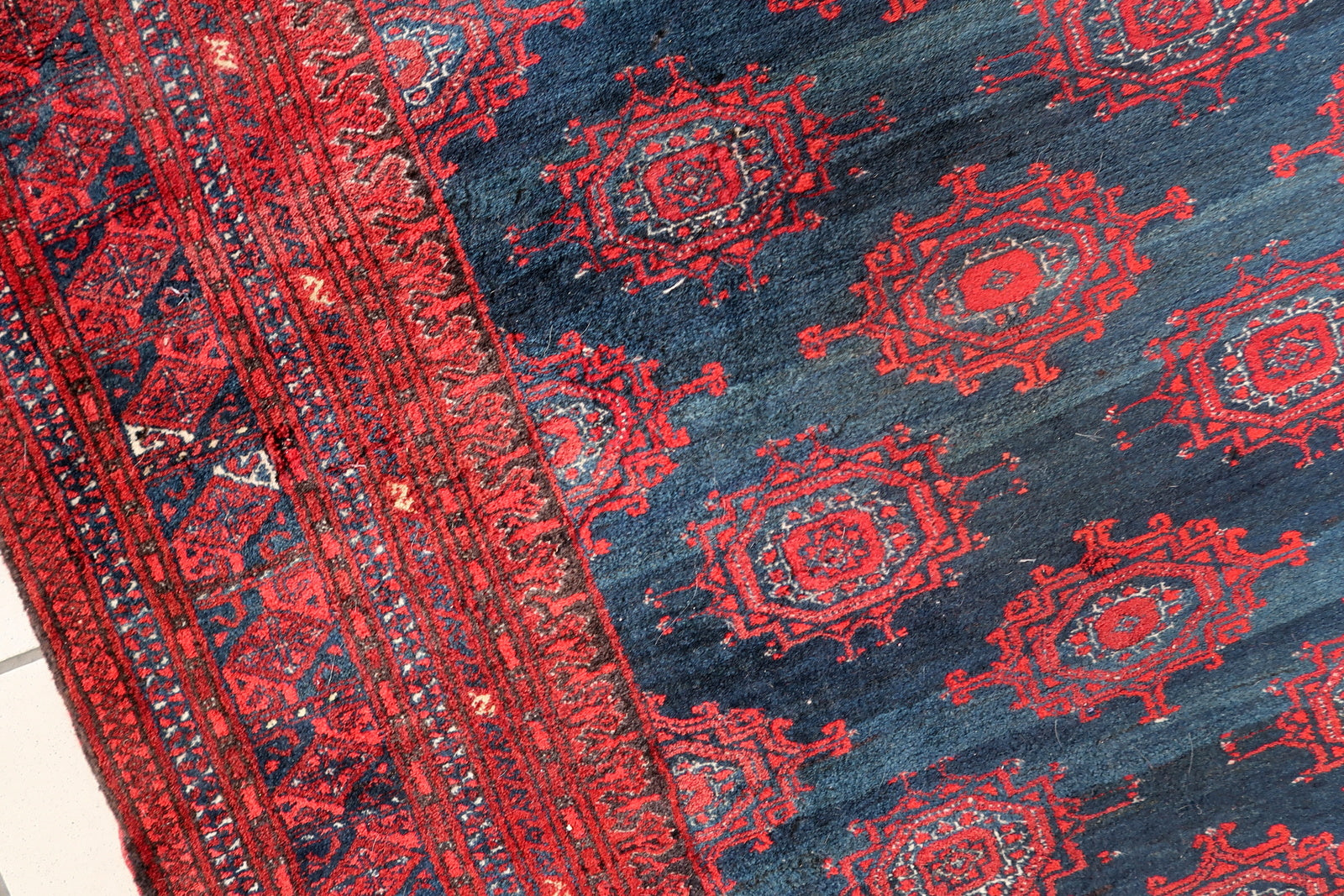 Handmade vintage Afghan Baluch rug in bright red and dark blue shades. The rug is from the middle of 20th century in original good condition.