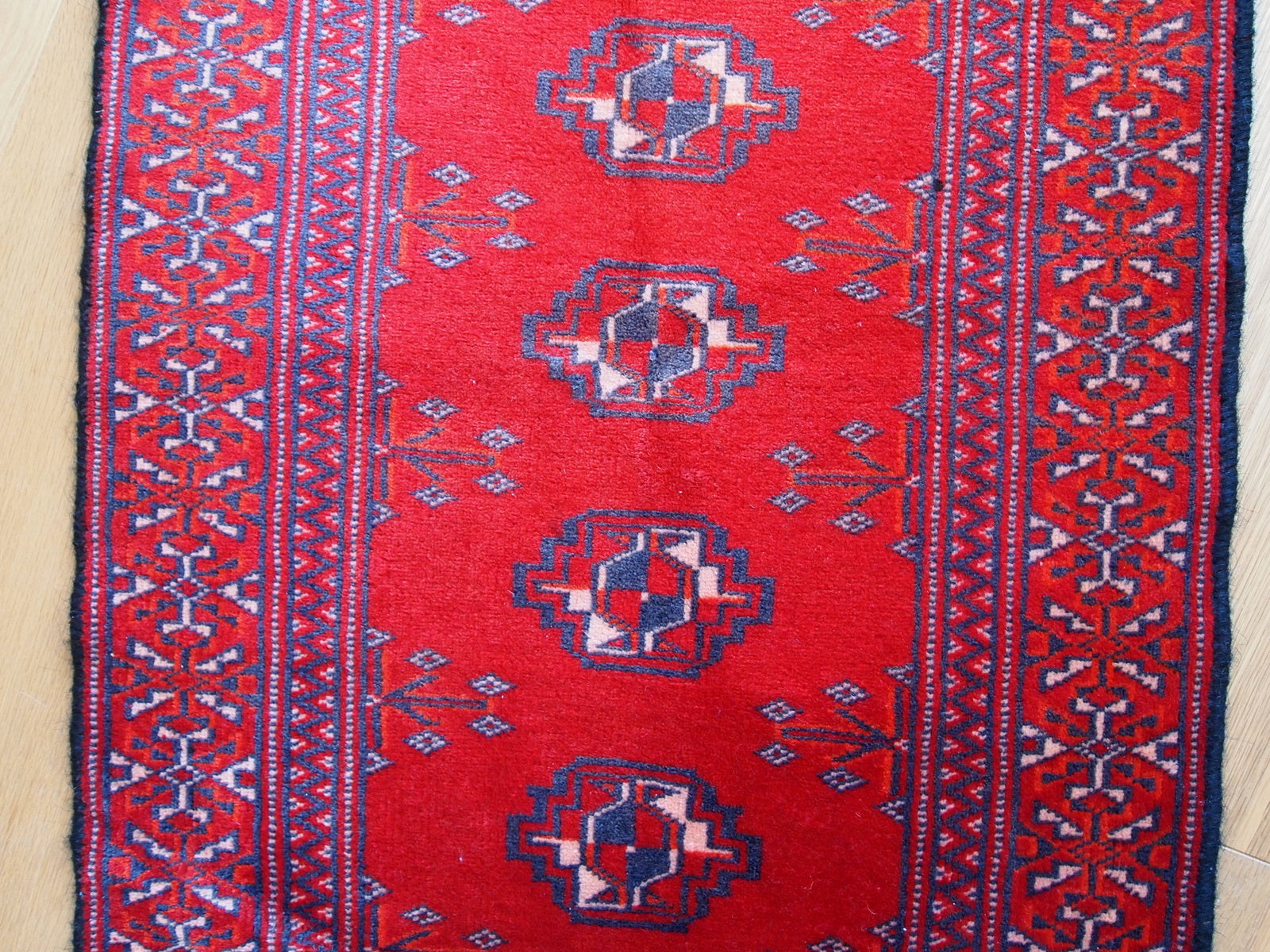 Detailed view of the striking bright red field of the Turkmen Rug