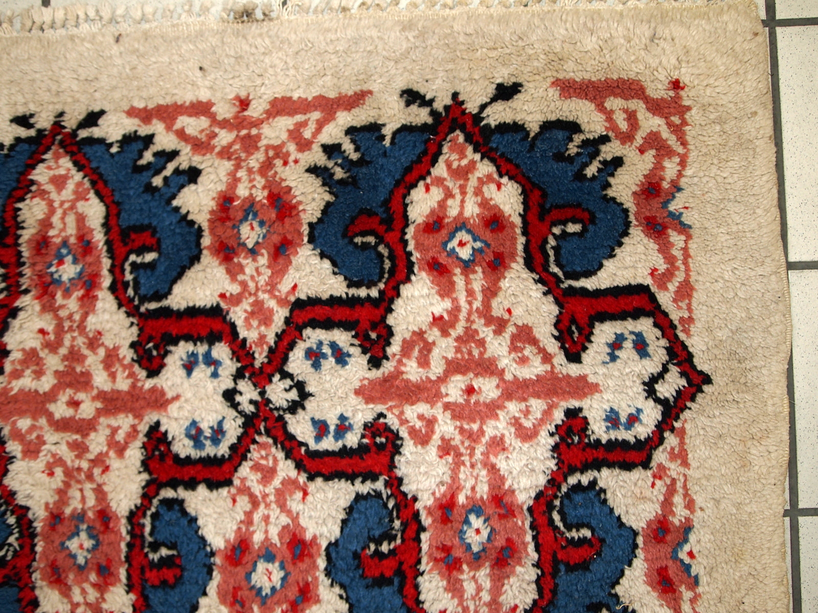 Handmade vintage Moroccan Berber rug in white, blue and red wool. The rug is in original good condition, from the end of 20th century.