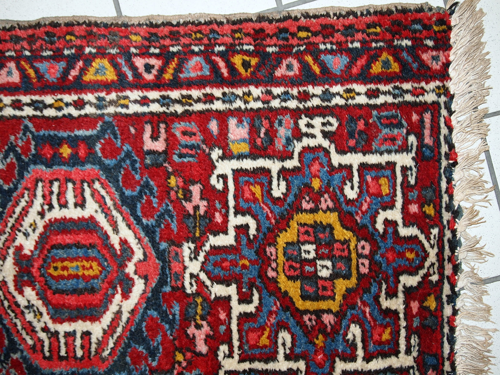 Handmade antique Persian Karajeh rug in original good condition. It has been made in the beginning of 20th century in red wool.