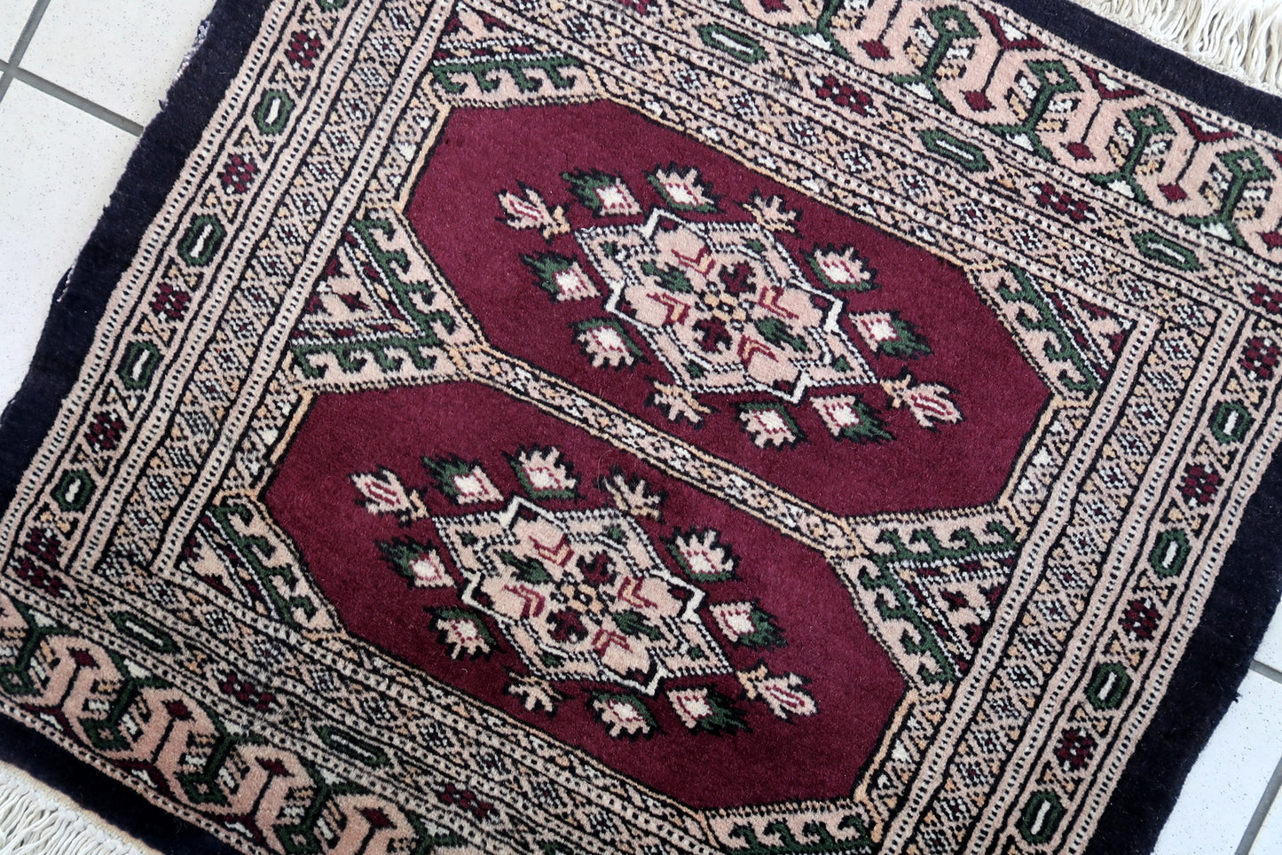 Handmade vintage Uzbek Bukhara mat in original good condition. The rug has been made in wool in the end of 20th century.