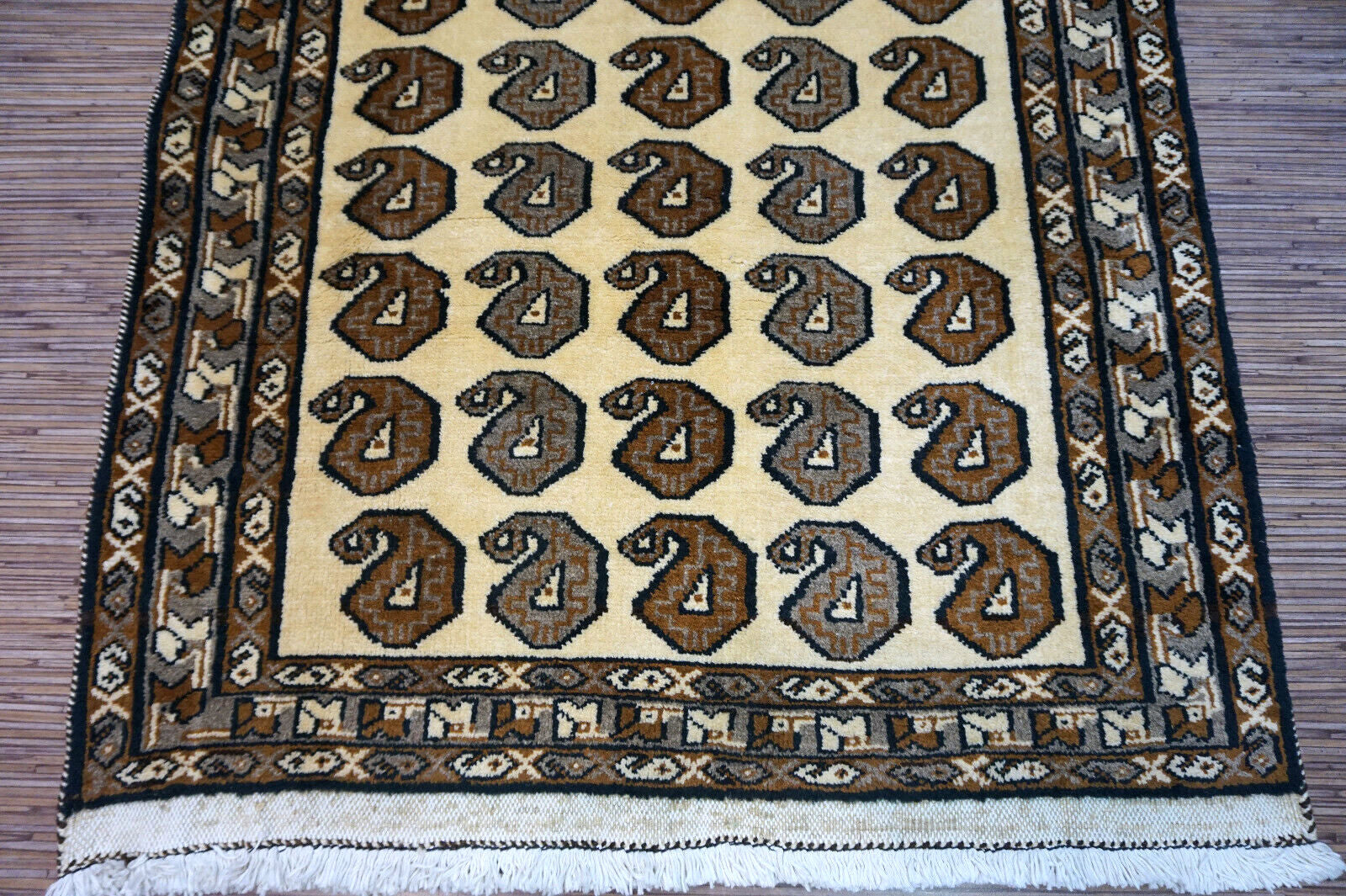 Handmade vintage Persian Gabbeh rug in beige color with repeating paisley design. The rug is from the end of 20th century in original good condition.