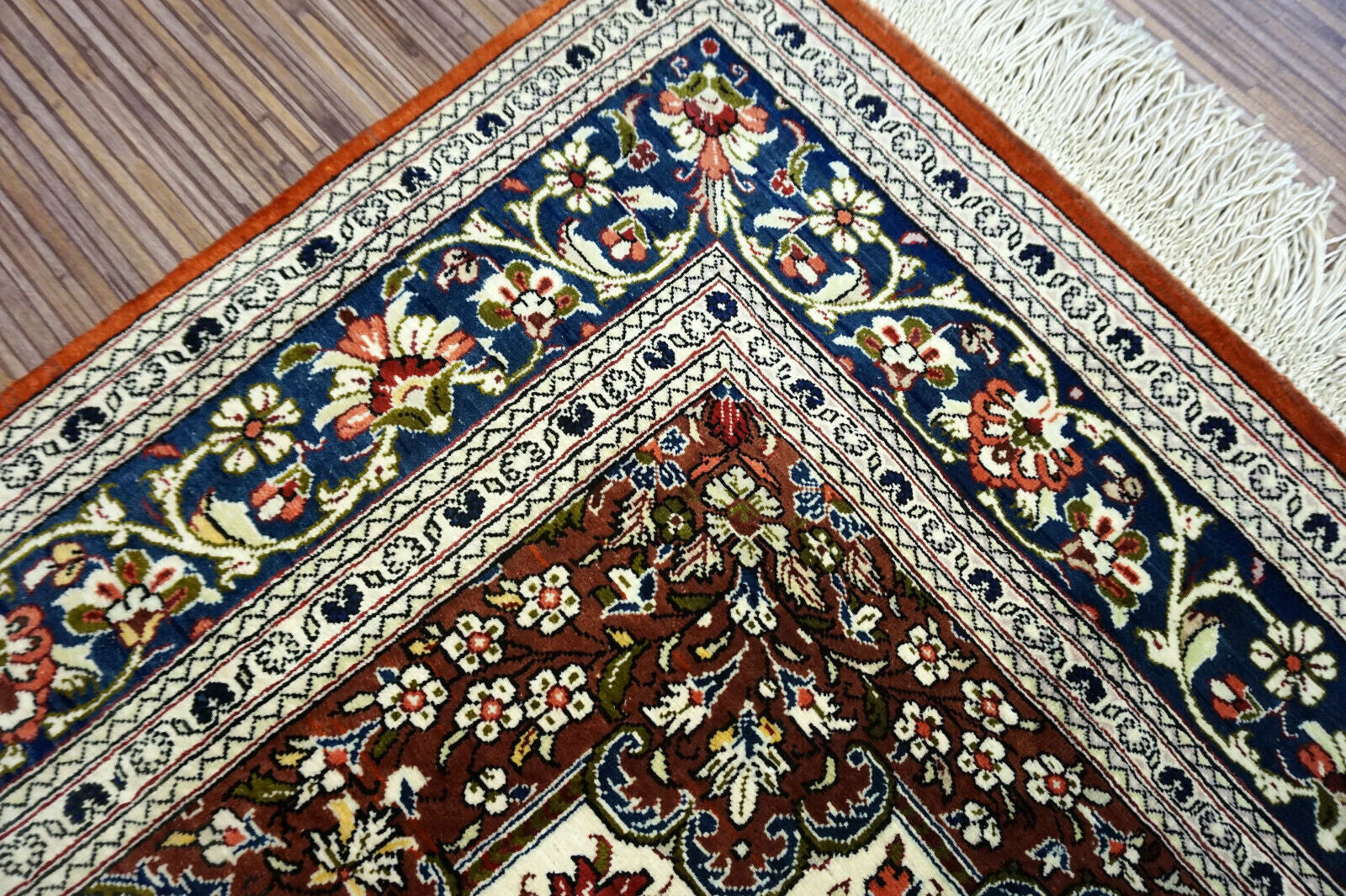 Handmade vintage Persian Qum rug in very busy floral design with natural colors. The rug has been made in silk. It is is from the end of 20th century in original good condition.